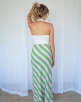 White cotton-blend Veronica twist top with a halter neckline, worn with a green and pink striped maxi skirt.
