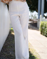 White wide-leg linen pants featuring a clean, flat front design and a breezy, relaxed fit.