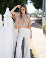 Woman wearing white wide-leg linen pants with a clean, back-zip design and breezy fit.