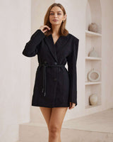 Black Zara blazer dress with notch lapels, long sleeves, and a tie-waist detail in a tailored, long-line fit.