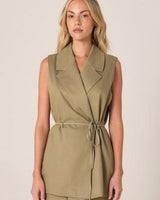Olive green sleeveless wrap vest with a notched lapel and self-tie waist belt in a tailored cotton-lyocell blend.