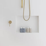 Al.ive Hair & Body Travel Pack bottles displayed in a shower niche with gold fixtures